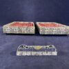 12 geslepen kristallen messenleggers in 2 kartonnen doosjes. Formaat van het doosje 14 x 9,5 cm.
